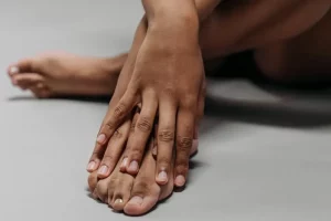 Foto de una mujer mostrando sus dedos de manos y pies